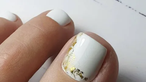 9 diseños de uñas blancas con dorado que puedes usar en los pies para lucir en natación