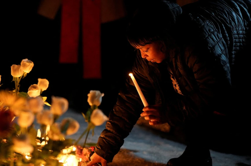 Una mujer reacciona junto a un sitio conmemorativo durante una vigilia por una mujer de 37 años que recibió un disparo en su automóvil por parte de un agente de inmigración de EE. UU., según funcionarios locales y federales, en Minneapolis