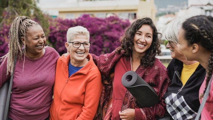 Cinco mujeres se ríen en círculo.
