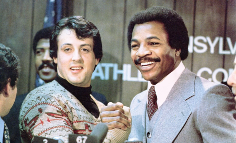Carl Weathers y Sylvester Stallone durante una conferencia de prensa previo al estreno de Rocky en 1976