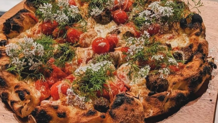 Una pizza recién hecha por los dueños de Pizzeria Sei