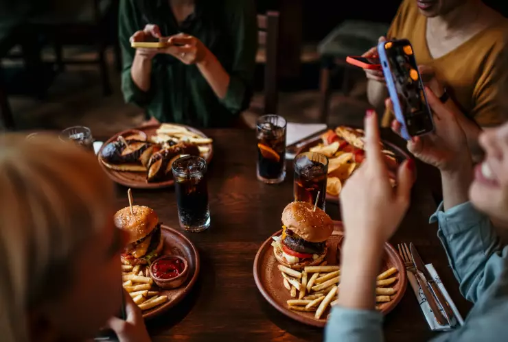 Cuatro personas comen hamburguesas en un restaurante
