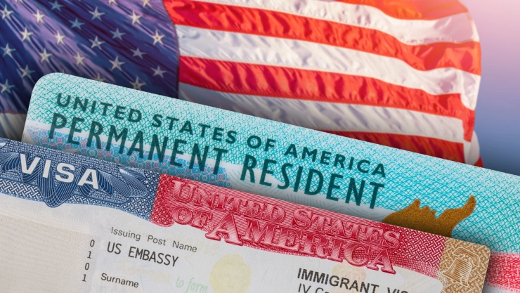 Una bandera de Estados Unidos, una Green Card y una visa americana.