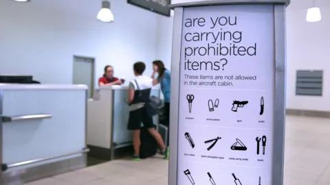 Un letrero informativo sobre los objetivos prohibidos en un aeropuerto.