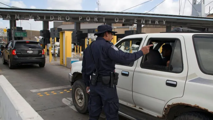 Un oficial de la CBP dirige a los coches en un puerto de entrada.