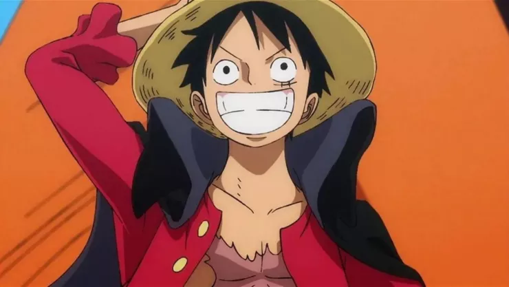 En la imagen, Luffy sonríe mientras sostiene su sombrero de paja.