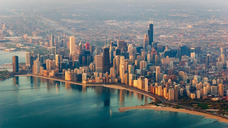 Vista aérea de la ciudad de Chicago al atardecer, con el río y los grandes edificios que reciben la última luz del sol