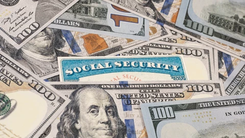 Billetes de 100 dólares alrededor de la tarjeta del Seguro Social de EU