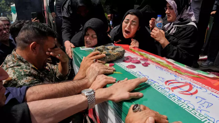 Iraníes lloran sobre el ataúd de un pariente muerto en la guerra con Israel.