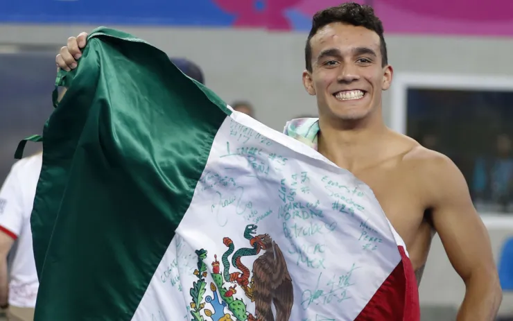 El mexicano Juan Celaya posa con su bandera tras ganar la presea de oro en los clavados, trampolín de un metro, en los Juegos Panamericanos de Lima, el jueves 1 de agosto de 2019. Imagen: AP