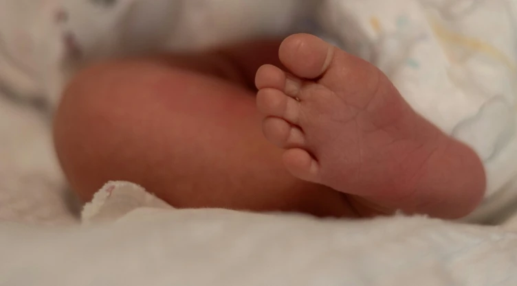 Pie de bebé recién nacido en cuna de hospital.