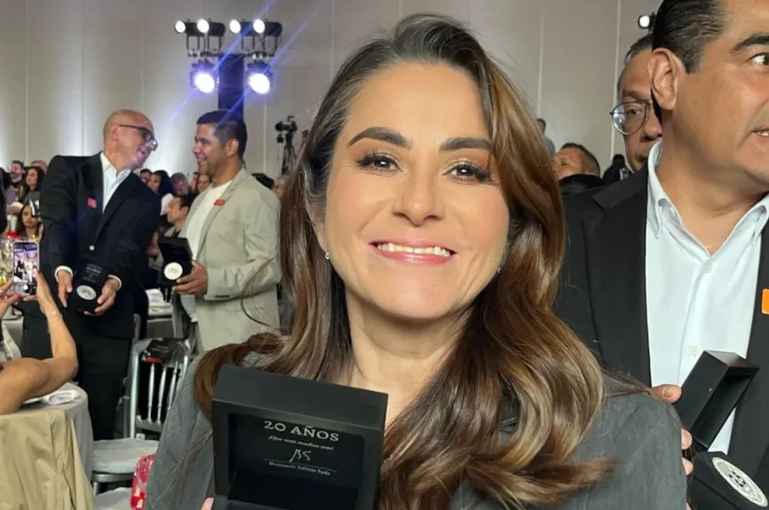 Empleada de TV Azteca sonriendo mientras se hace la entrega del galardón institucional “Vida y Movimiento”.