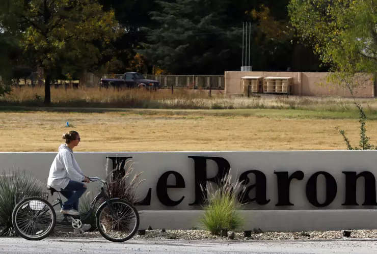 Una mujer pasa en bicicleta por delante del cartel de Colonia LeBarón, una comunidad establecida por miembros de la familia extendida LeBarón en el estado de Chihuahua, en el norte de México, el 6 de noviembre de 2019. Imagen: AP