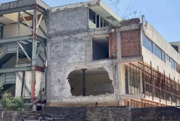 estructuras de madera y metal sostienen los pisos del colegio, también se ven algunos huecos en las paredes