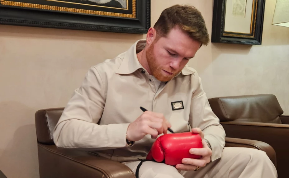 Canelo Álvarez firma unos guantes de box