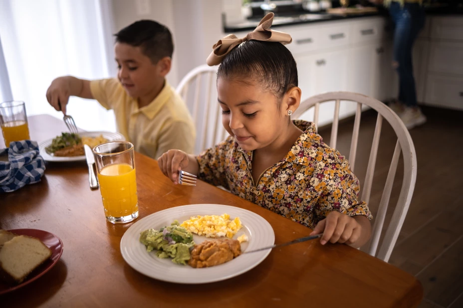 Siblings having breakfast at home