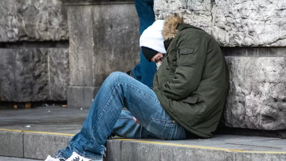 hombre acurrucado sentado en el piso
