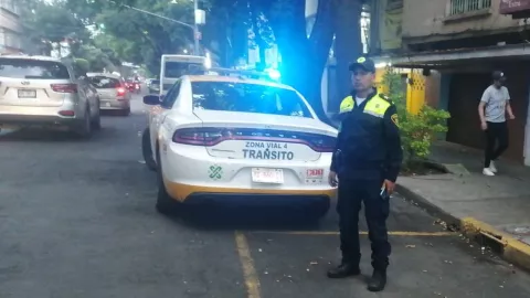 oficila de tránsito junto a su patrulla