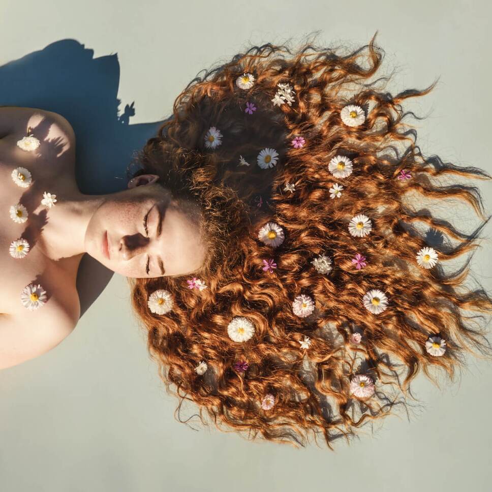 metodo curly hair mujer con flores en el pelo