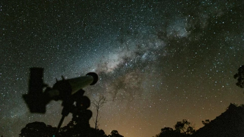 Telescopio apuntando a un cielo nocturno estrellado