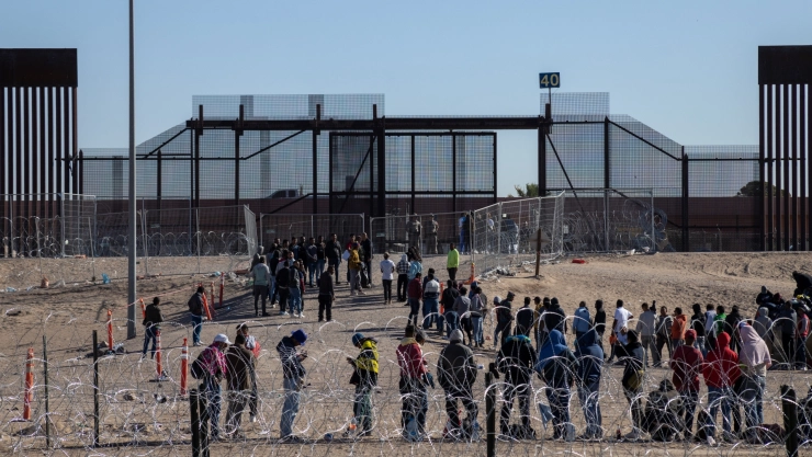 Personas hacen fila en la frontera entre México y Estados Unidos.