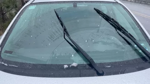 Parabrisas de auto con poca nieve encima