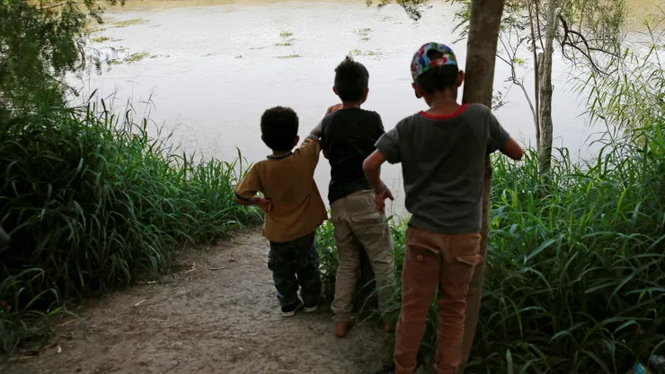 Niños migrantes de Centroamérica miran el Rio Bravo cerca del Puente Internacional Brownsville-Matamoros, donde se encuentra su campamento, en la frontera en Matamoros, Tamaulipas, México, el 27 de junio del 2019. Imagen: Reuters