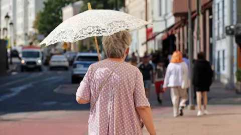 Una mujer con un paraguas para soportar el sol