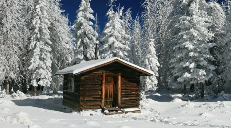 una pintoresca cabaña junto con un paisaje nevado