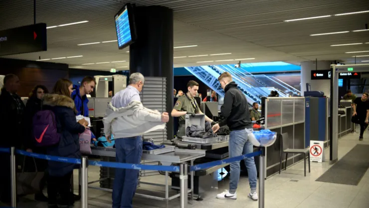 Personas pasan por un control de seguridad en un aeropuerto.