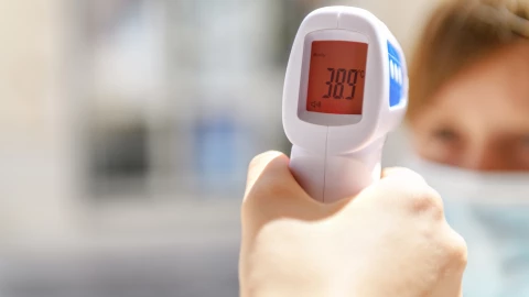 Un profesional de la salud toma la temperatura a un paciente.