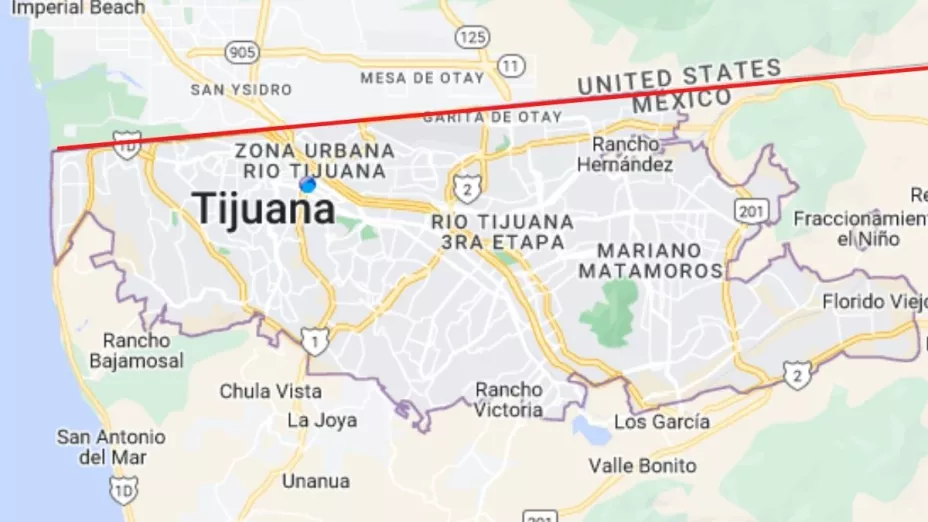 Mujer salvadoreña se atora al intentar cruzar el muro fronterizo de México a Estados Unidos.