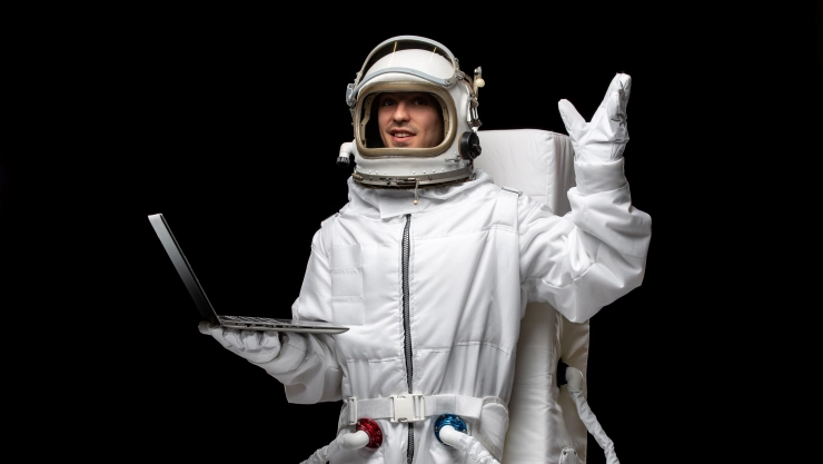 Astronauta con computadora en la mano ilustrando el internet en el espacio.