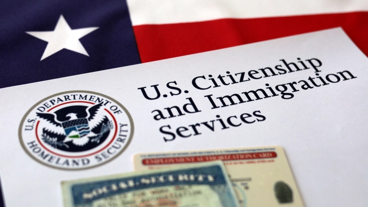 Un sobre con el nombre del USCIS sobre una bandera estadounidense