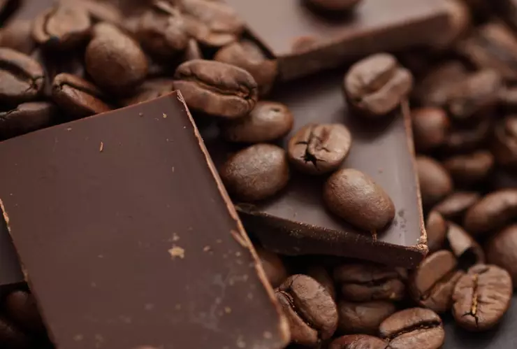 granos de café junto a una barra de chocolate