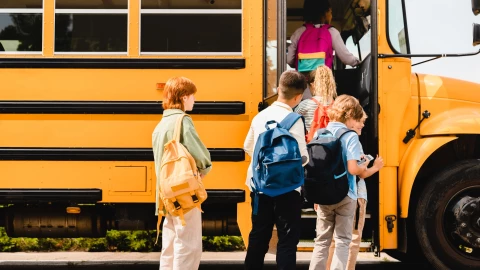 Niños suben a un autobús escolar.