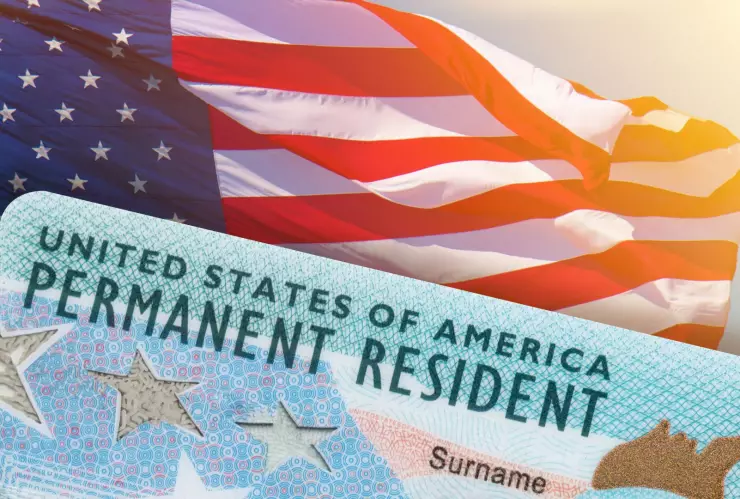 Una Green Card sobre una bandera estadounidense.
