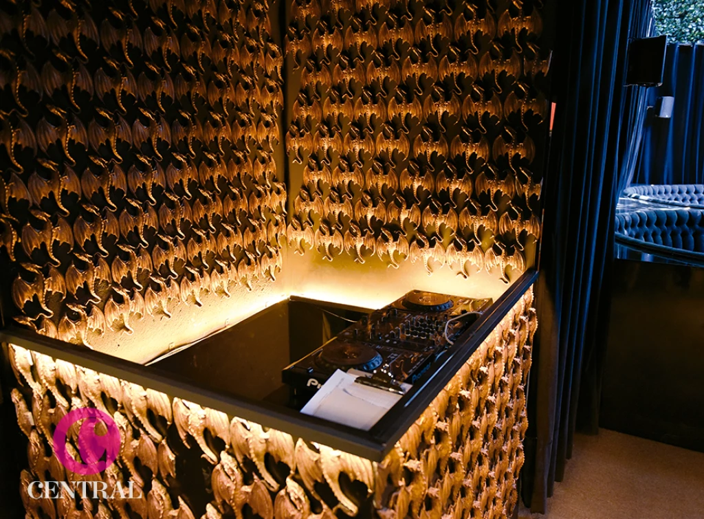 El dj booth está decorado con figuras de dragones de metal.