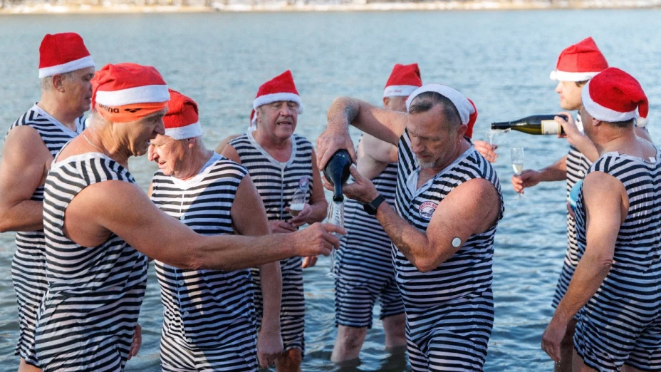 La gente bebe champán mientras celebra el año nuevo temprano al mediodía, en la víspera de Año Nuevo , junto al lago Bajer, en Fuzine, Croacia, el 31 de diciembre de 2025