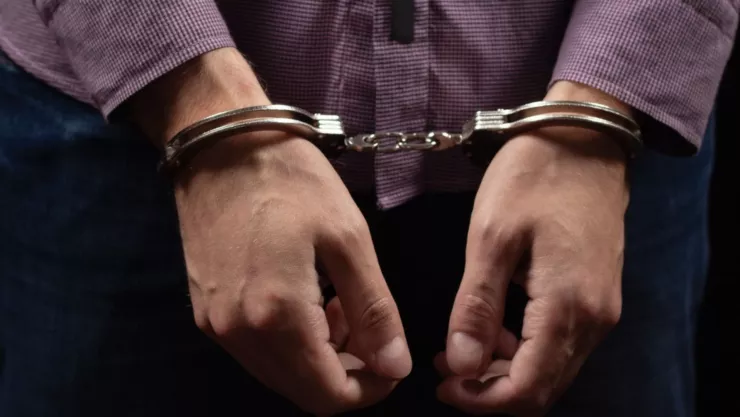 Foto de los brazos de un hombre esposado.