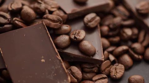 granos de café junto a una barra de chocolate