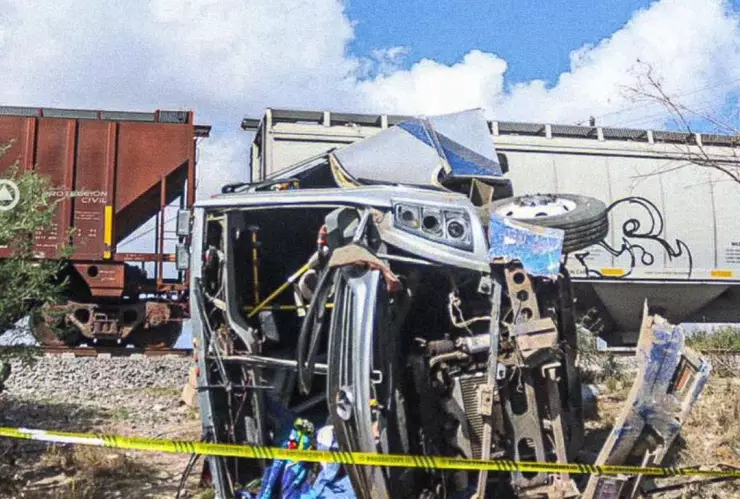 autob&uacute;s de pasajeros completamente destruido de la parte delantera, la unidad est&aacute; acordonada y a un lado del tren