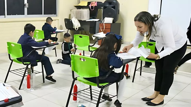 Maestra y alumnos en salón de clases