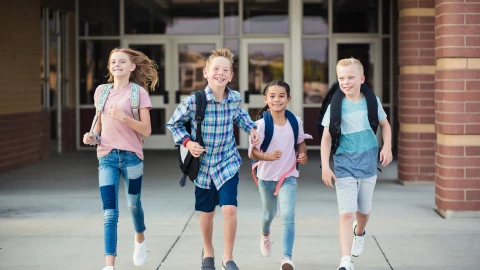 Niños salen de la escuela contentos