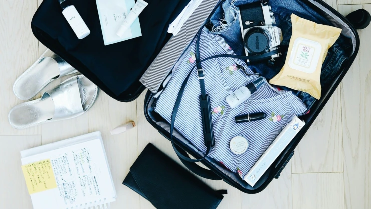 Maleta de viaje con ropa y cámara.