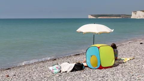 Unas personas están en la orilla del mar.