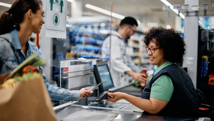 Una cajera de supermercado cobra las compras de una persona