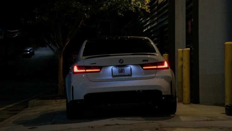 Automóvil sedán estacionado sobre banqueta.