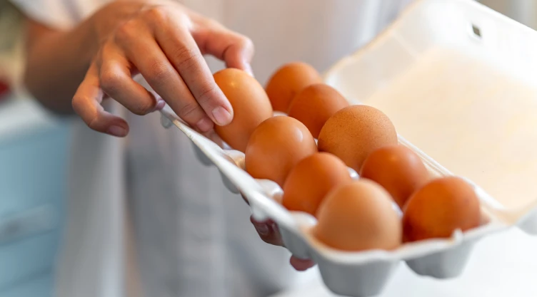 Hombre sostiene un cartón de huevos
