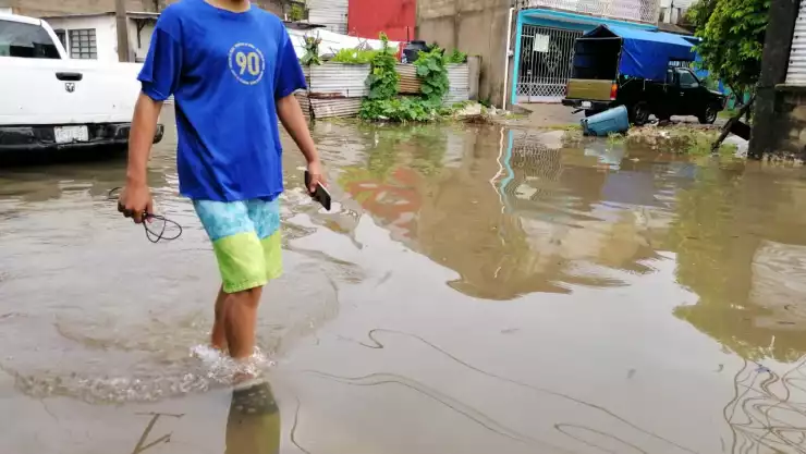 Niño camina por una calle bajo el agua en Villahermosa